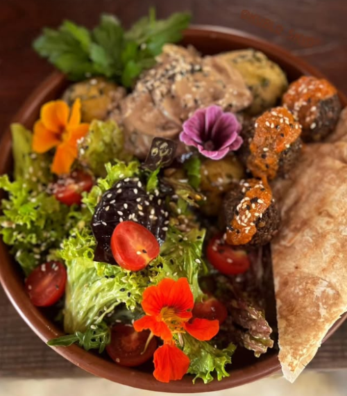 Страва з листками салату, томатами та квітами 